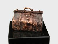 Figurine of doctor's bag on black base